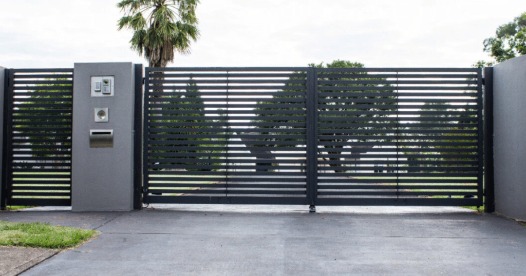 Modern black metal driveway gate closed.