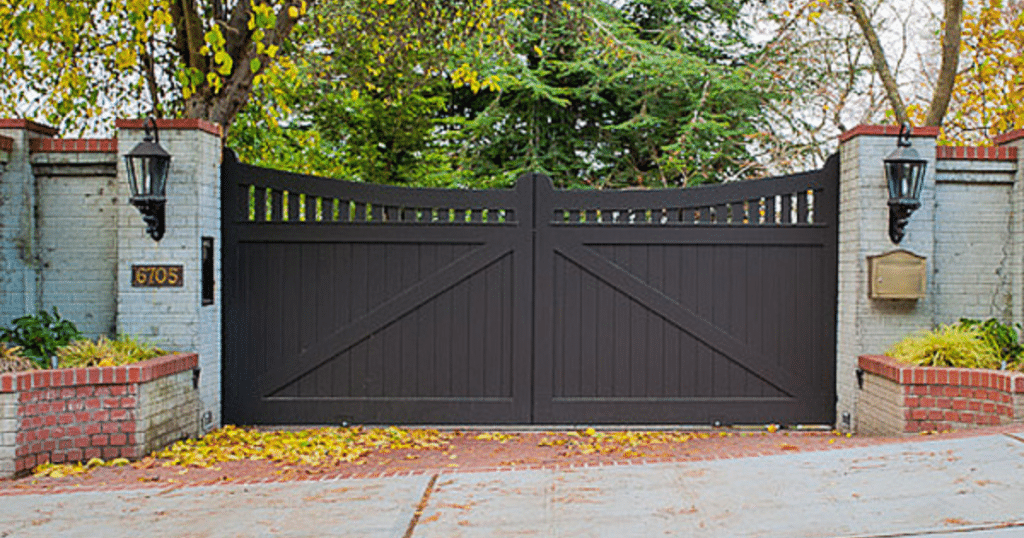 Black wooden gate with brick columns.