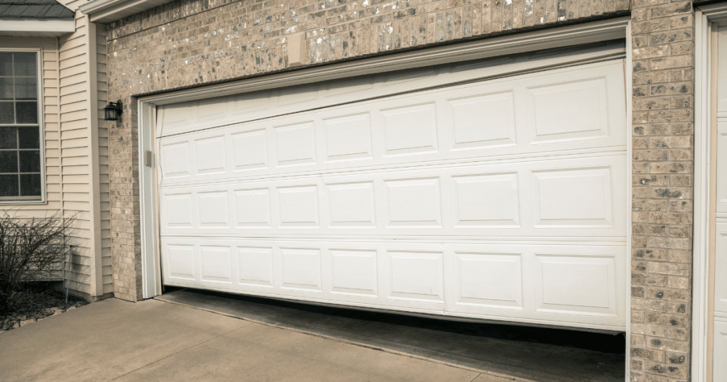 White garage door stuck open, misaligned.
