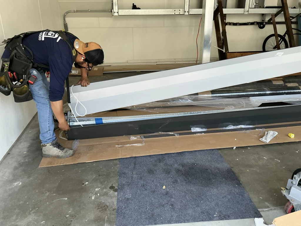 A technician preparing insulated garage door panels inside a garage, demonstrating the process of a 16x8 garage door insulation setup.