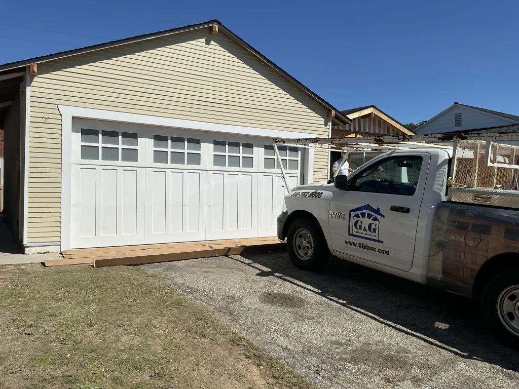 A service truck parked in front of a house, showcasing the solution when there are signs your garage door requires maintenance.