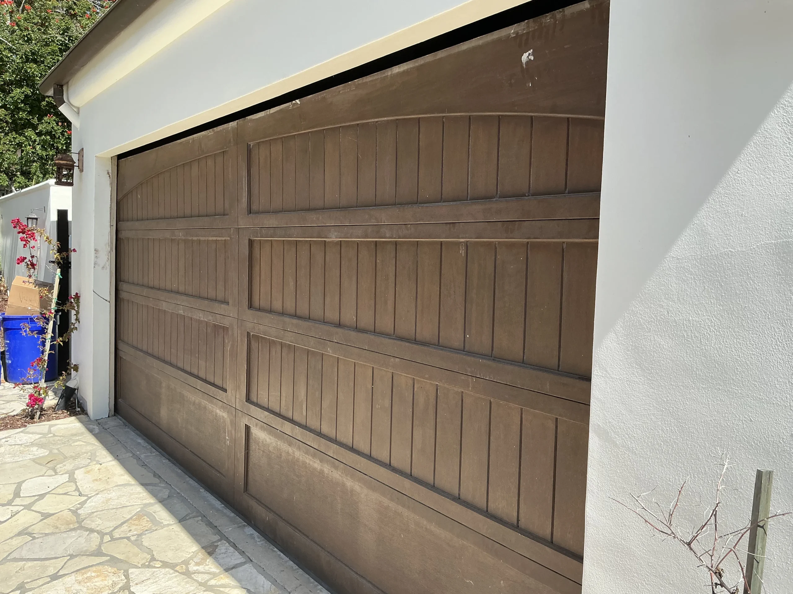 A close-up view of a custom dark-stained sectional timber garage door, highlighting the detailed craftsmanship of a handcrafted wooden garage door.