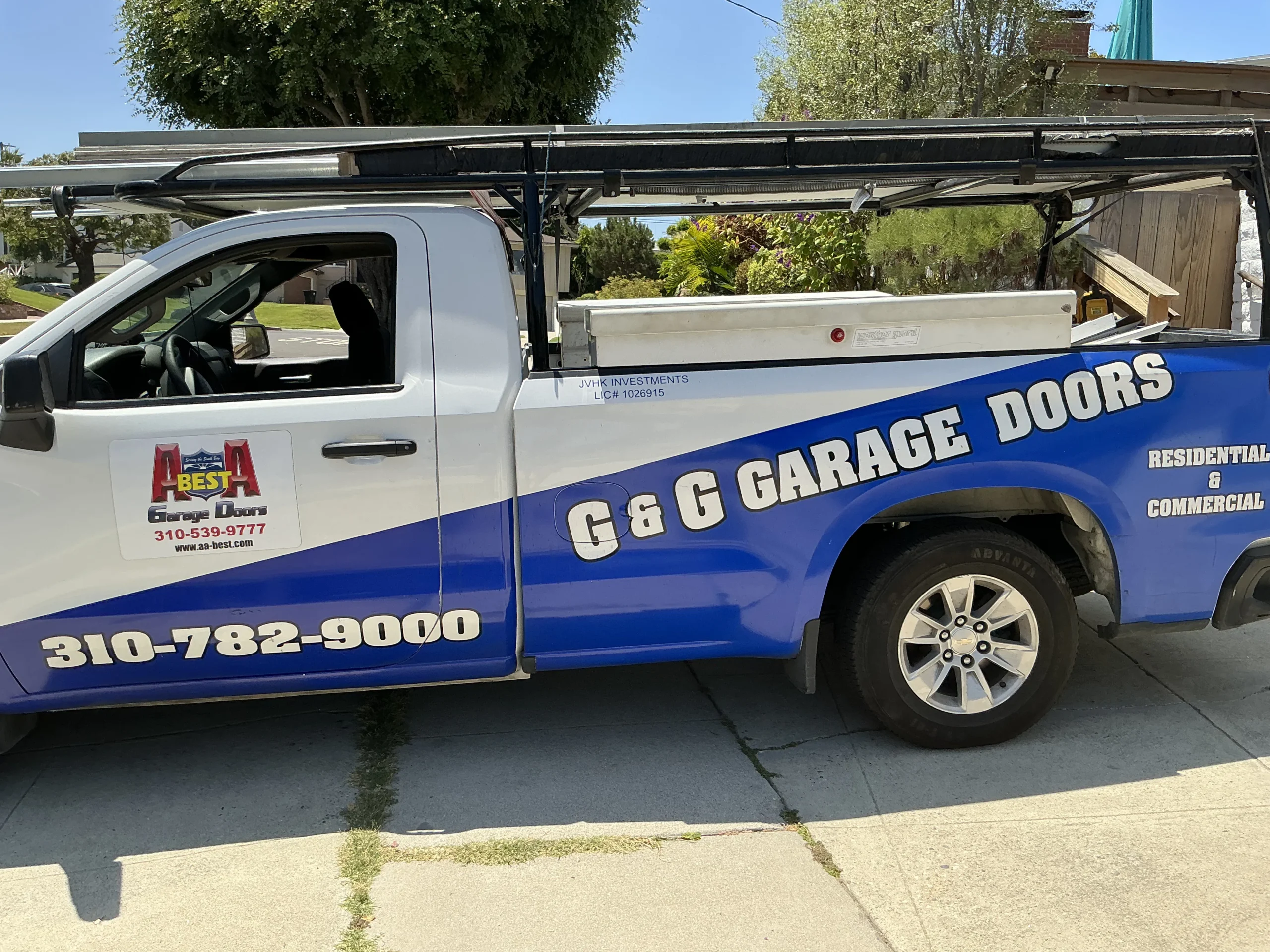 A branded service truck parked on a sunny driveway, representing a professional 9x8 garage door installation in Torrance, CA.