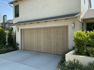 A contemporary home featuring a vertical wood-plank style door, showcasing the clean exterior finish of a vinyl backed garage door.